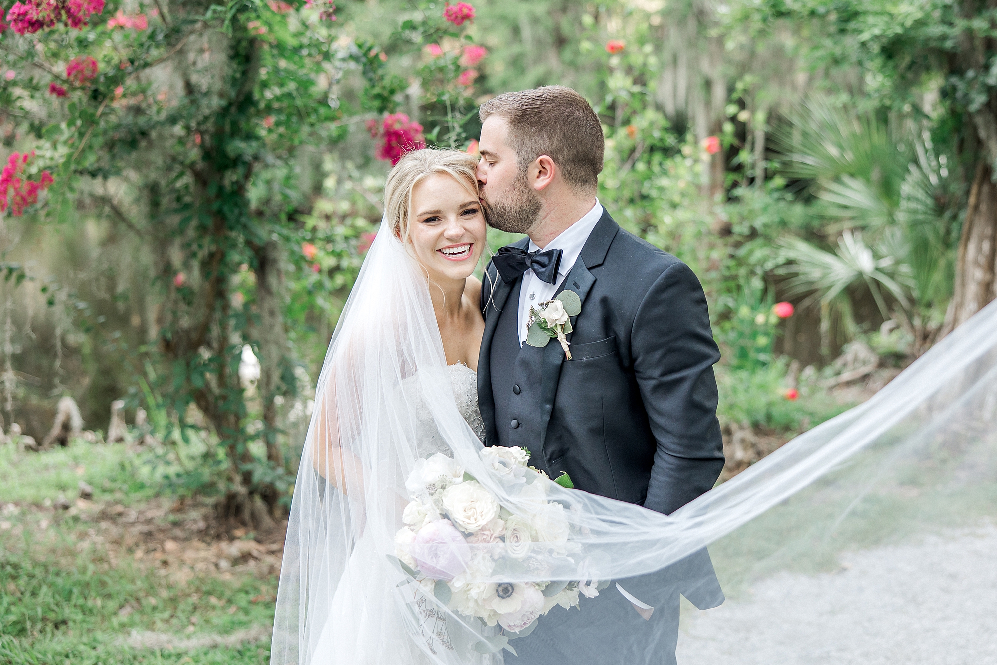 groom kiss brides forehead during wedding portraits