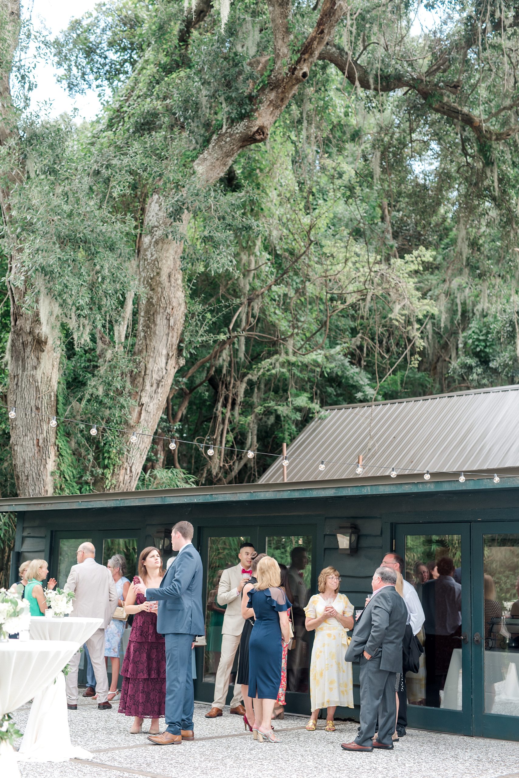 wedding guests mingle on outside patio at Magnolia Plantation and Gardens