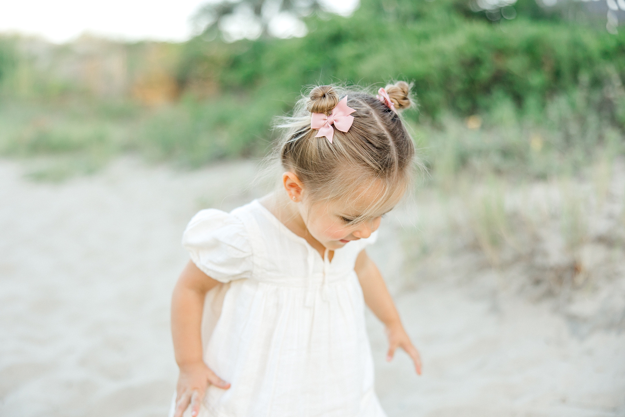 little girl explores in the sand