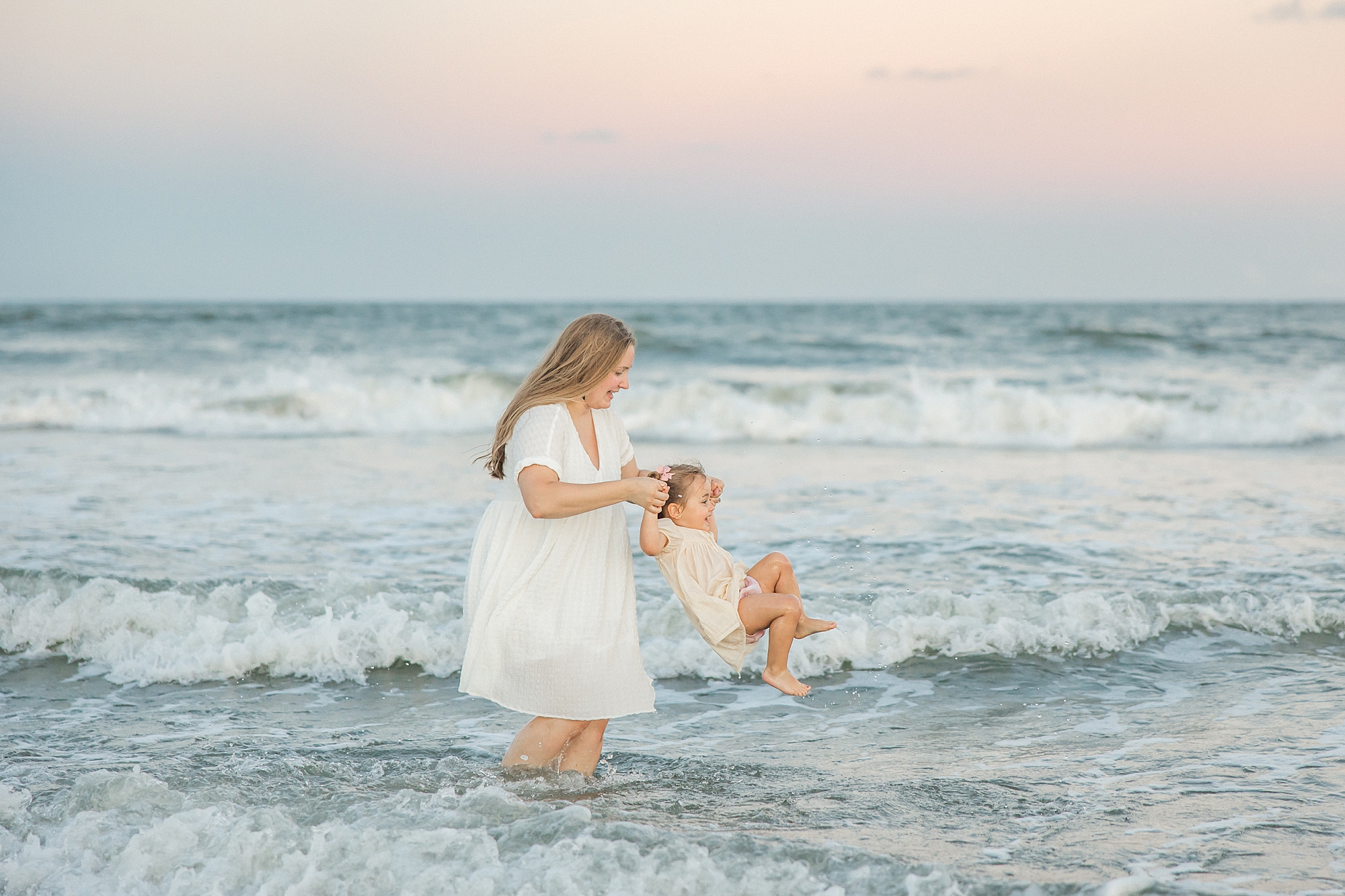 mother and daughter play in the ocean waves Isle of Palms