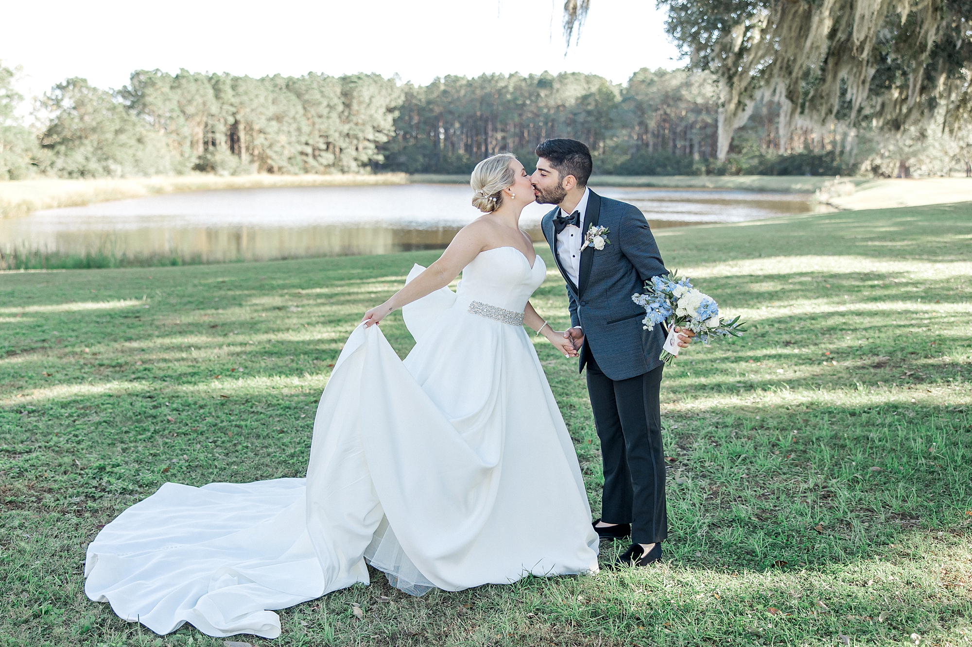couple kiss by pond at Southern wedding venue Wingate Place