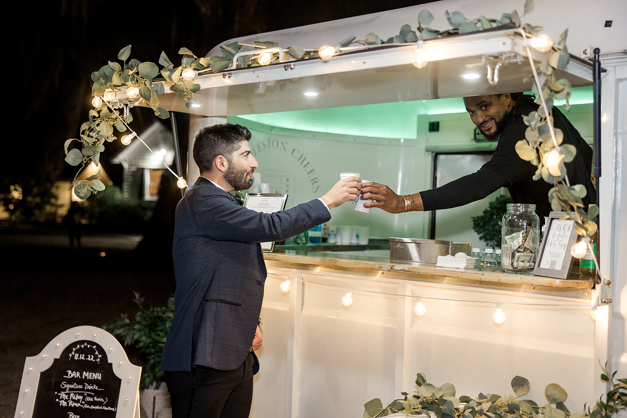 groom gets drink from mobile bar