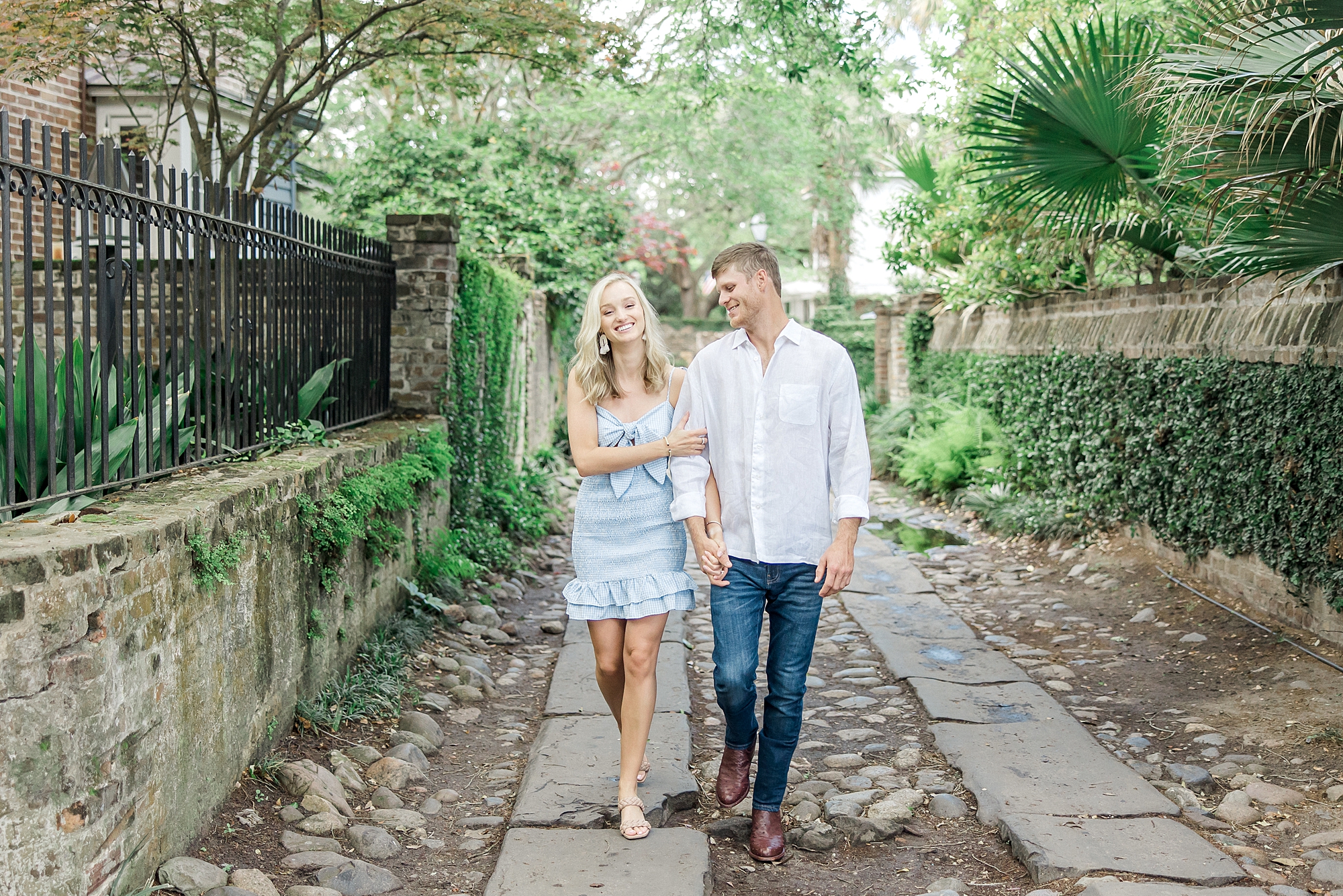 engaged couple walk down historic downtown Charleston for engagement session
