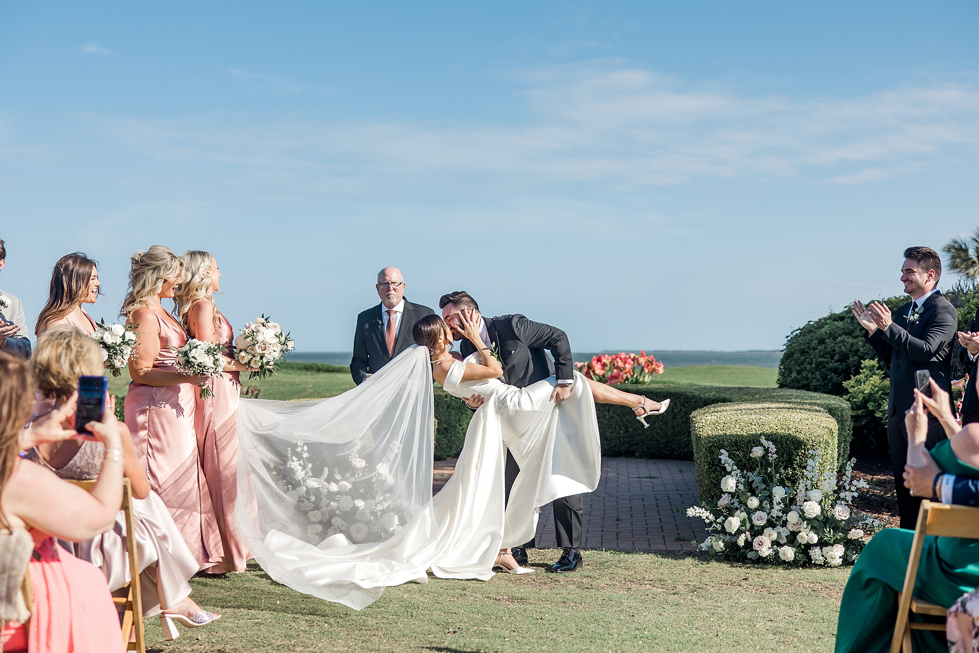 groom kisses and dips his bride after Waterfront Charleston Wedding