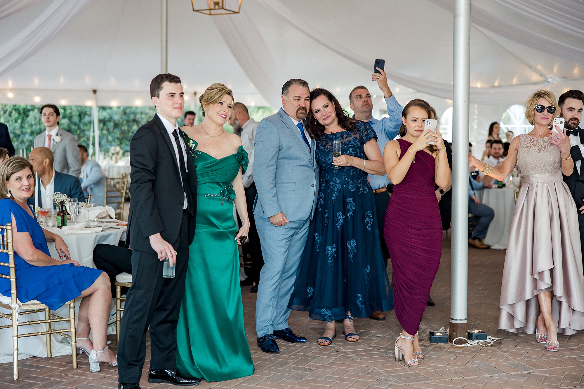 wedding guests take pictures of newlyweds dancing