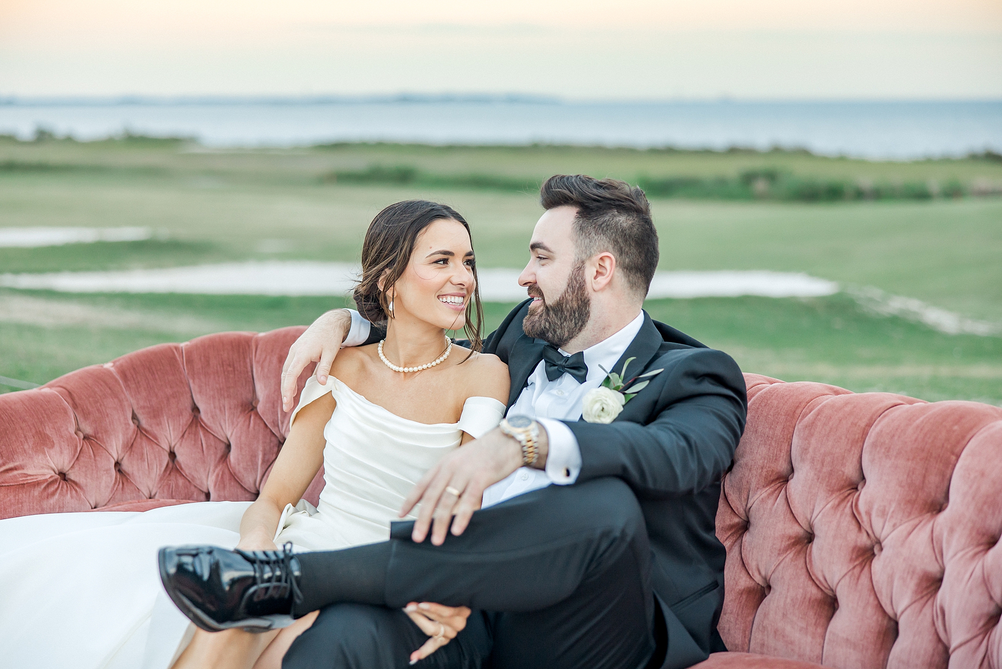 bride and groom sit on couch from Waterfront Charleston Wedding at Patriots Point Links