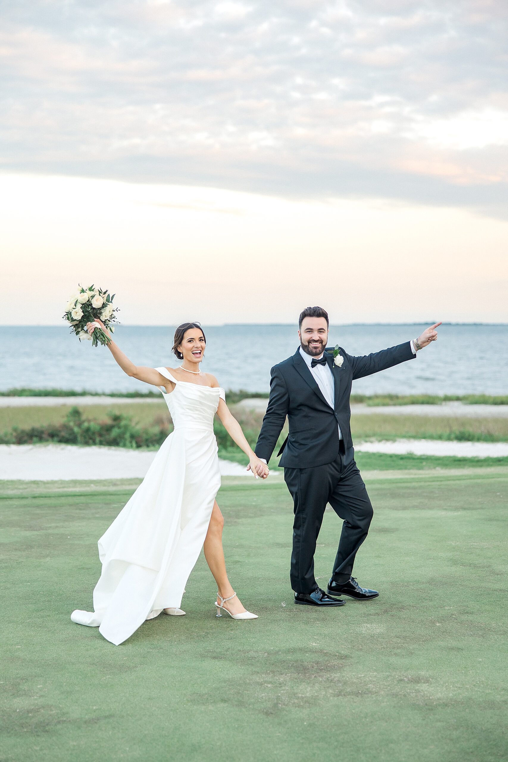 newlyweds celebrate by the water during wedding portraits