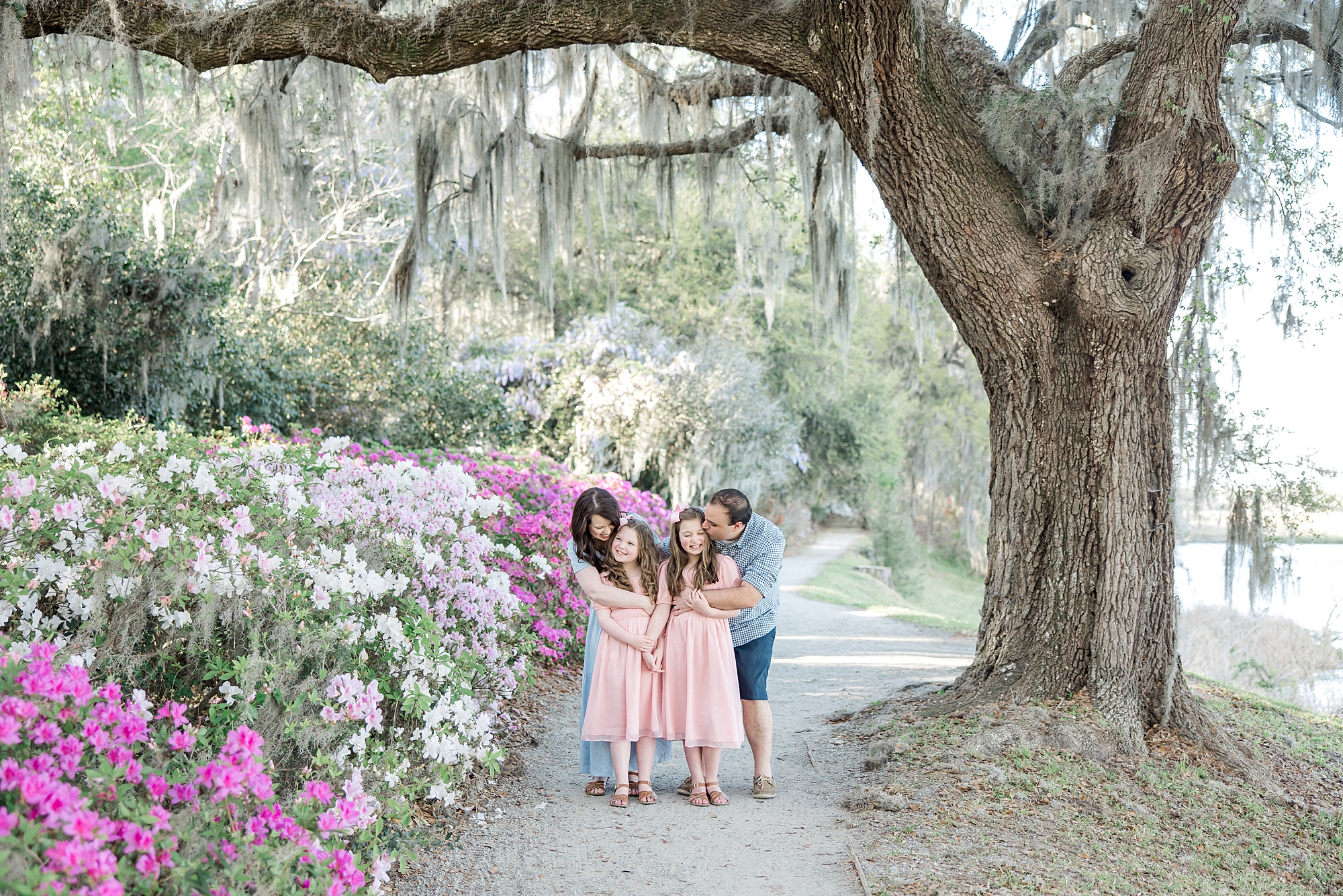 parents hug their two girls in the gardens at Middleton Place