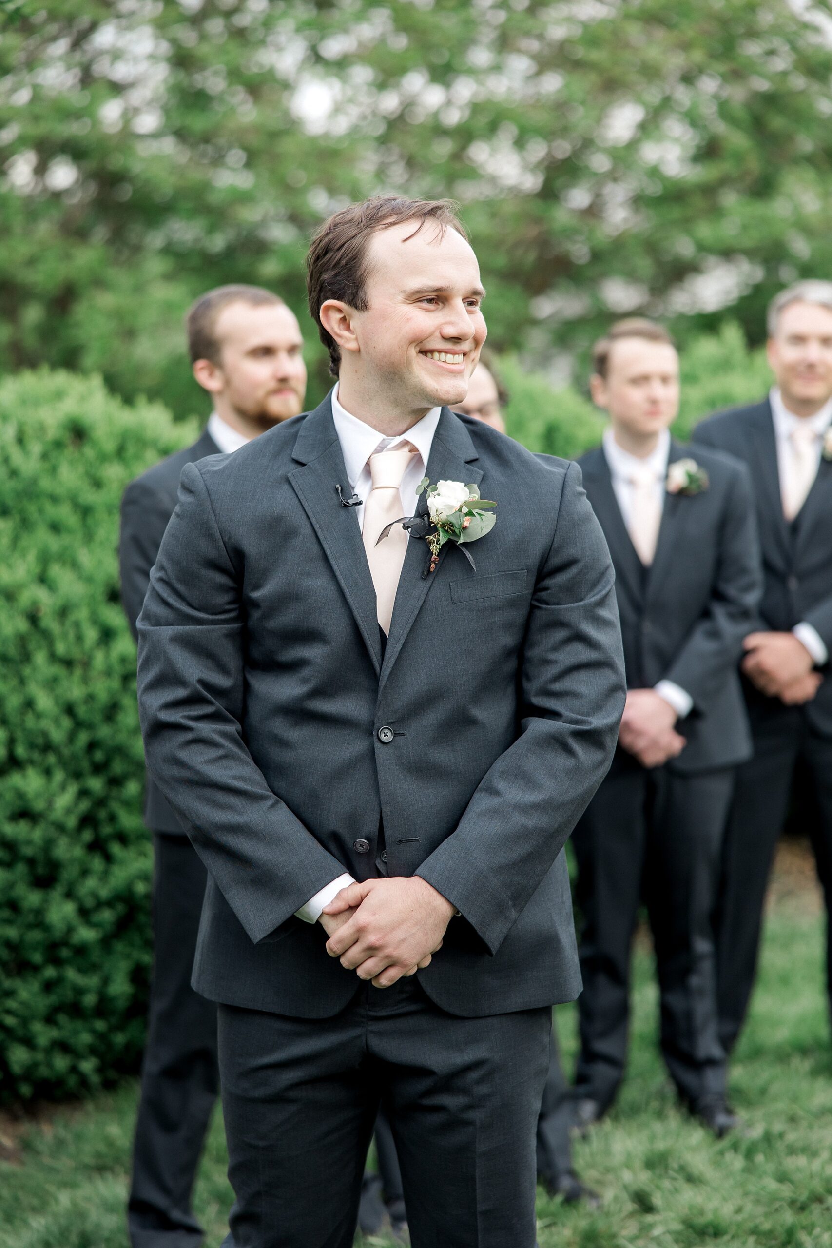 groom watching his bride walking down the aisle