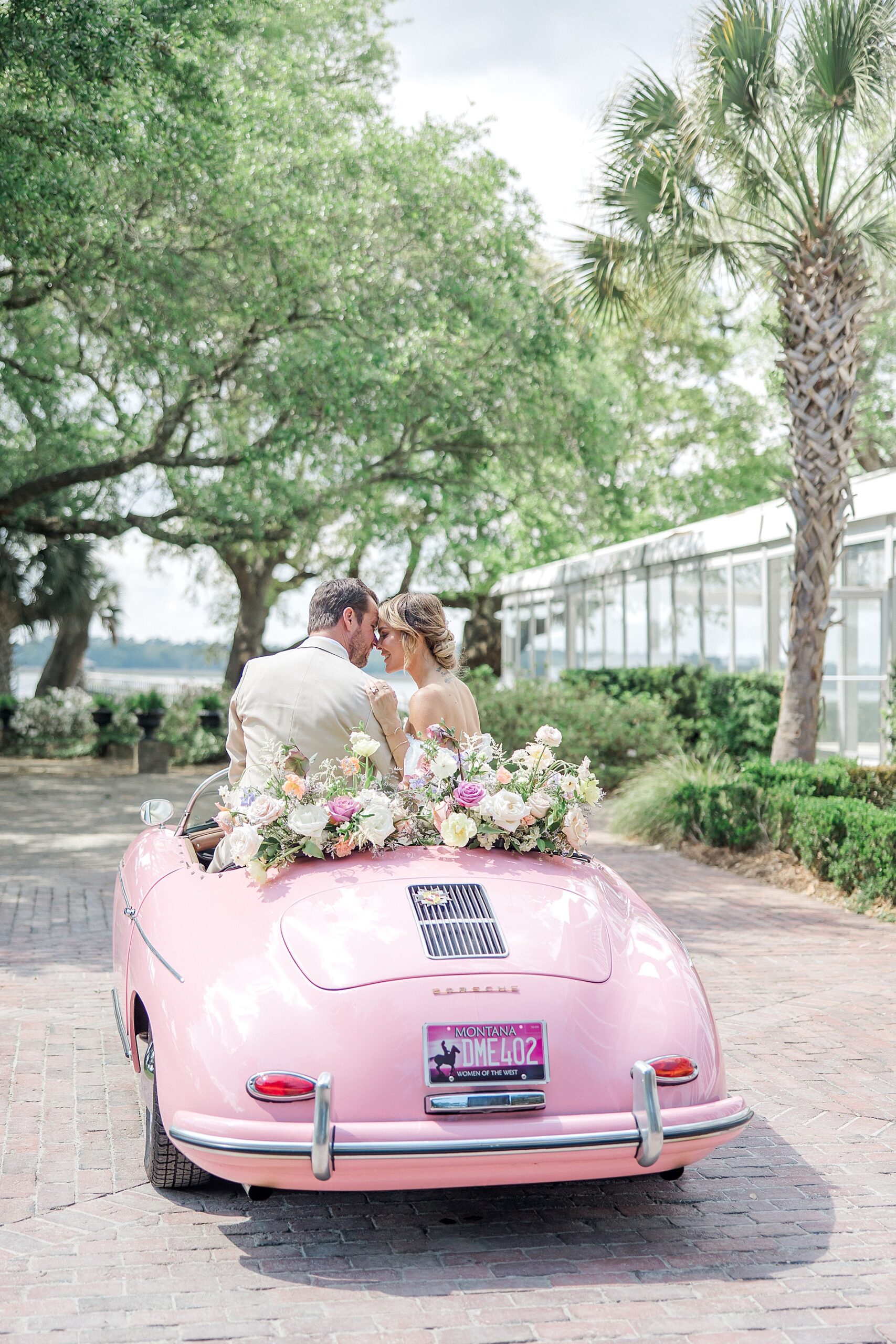 newlyweds drive off in pink Porsche after Luxury Spring Wedding at Lowndes Grove