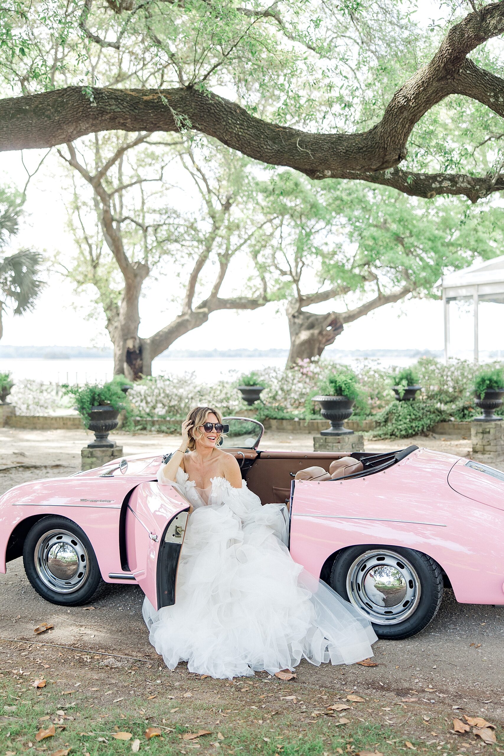 bride wearing sunglasses in vintage pink Porsche