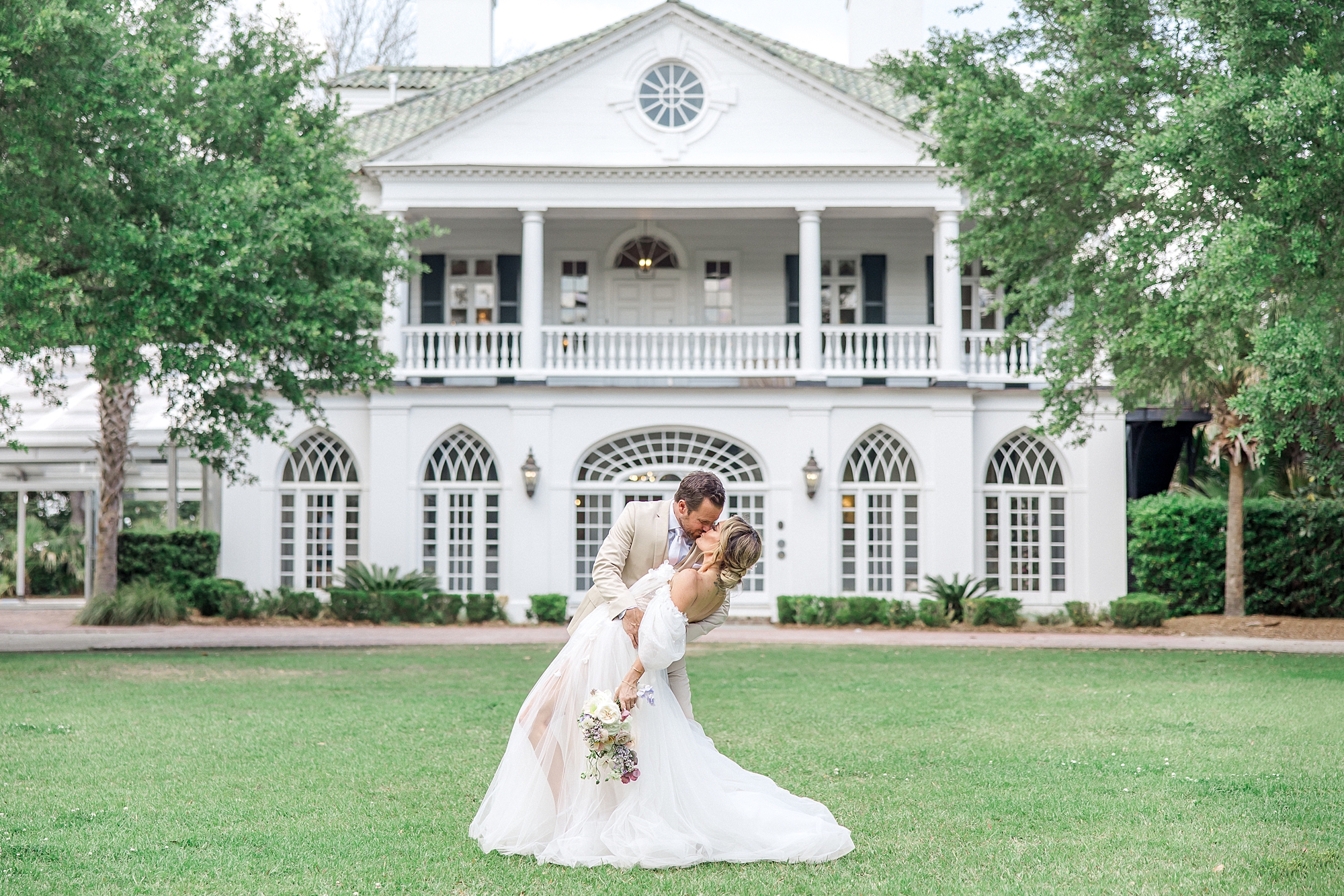 newlyweds kiss outside of Luxurious Wedding venue at Lowndes Grove