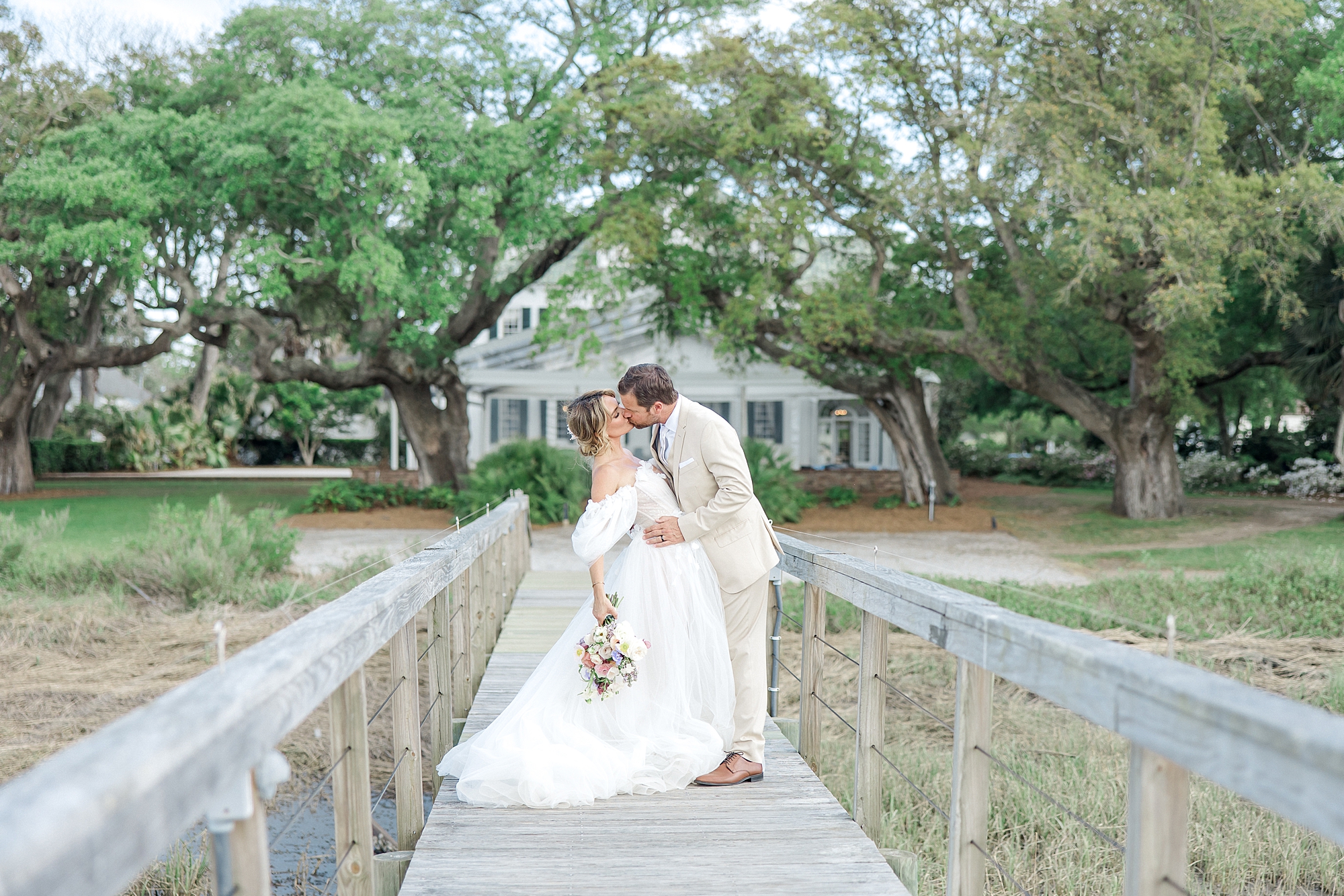 bride and groom kiss on bridge from Charleston wedding
