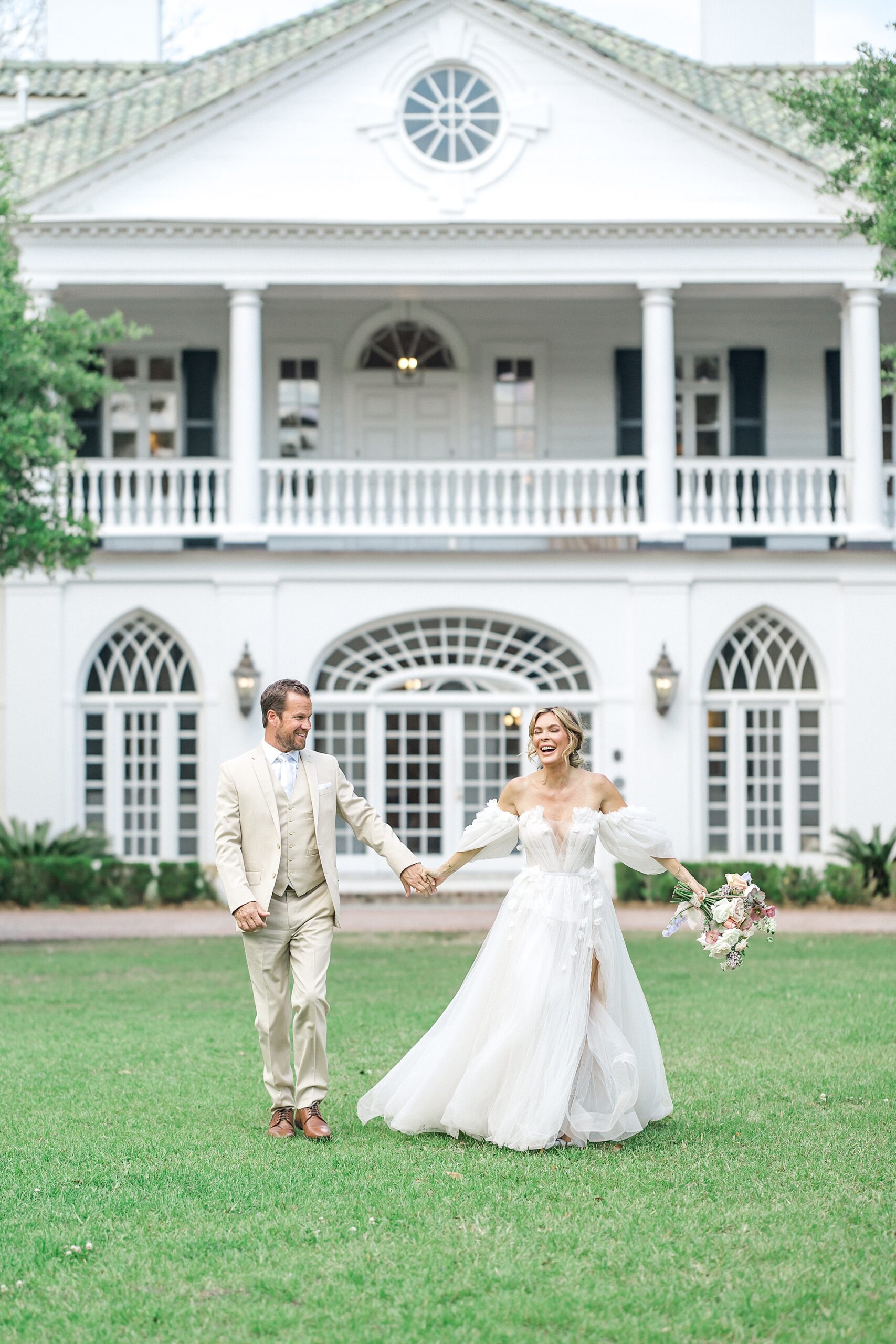 bride and groom outside of white estate at Lowndes Grove