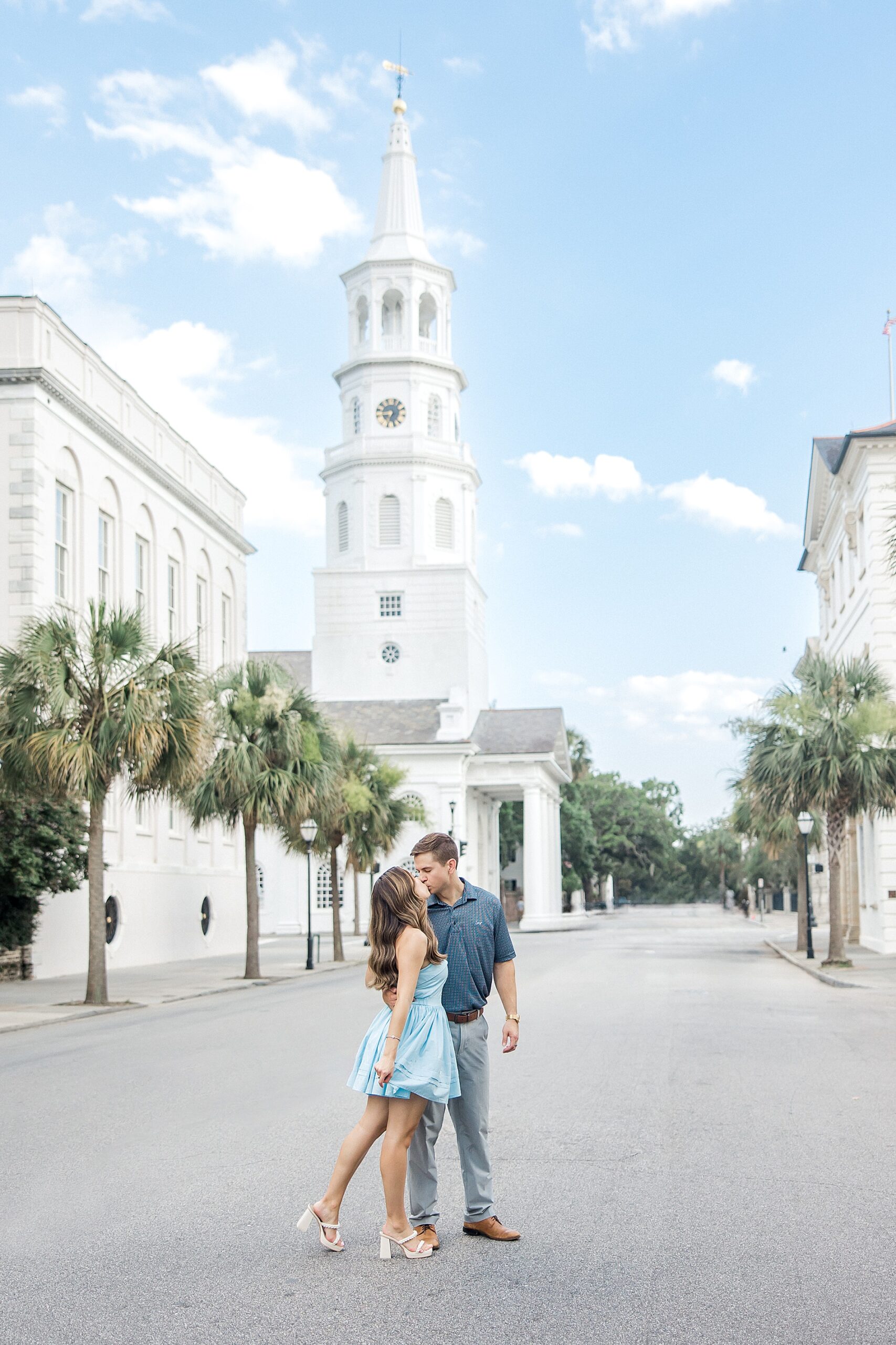 engaged couple by old church steeple in downtown Charleston