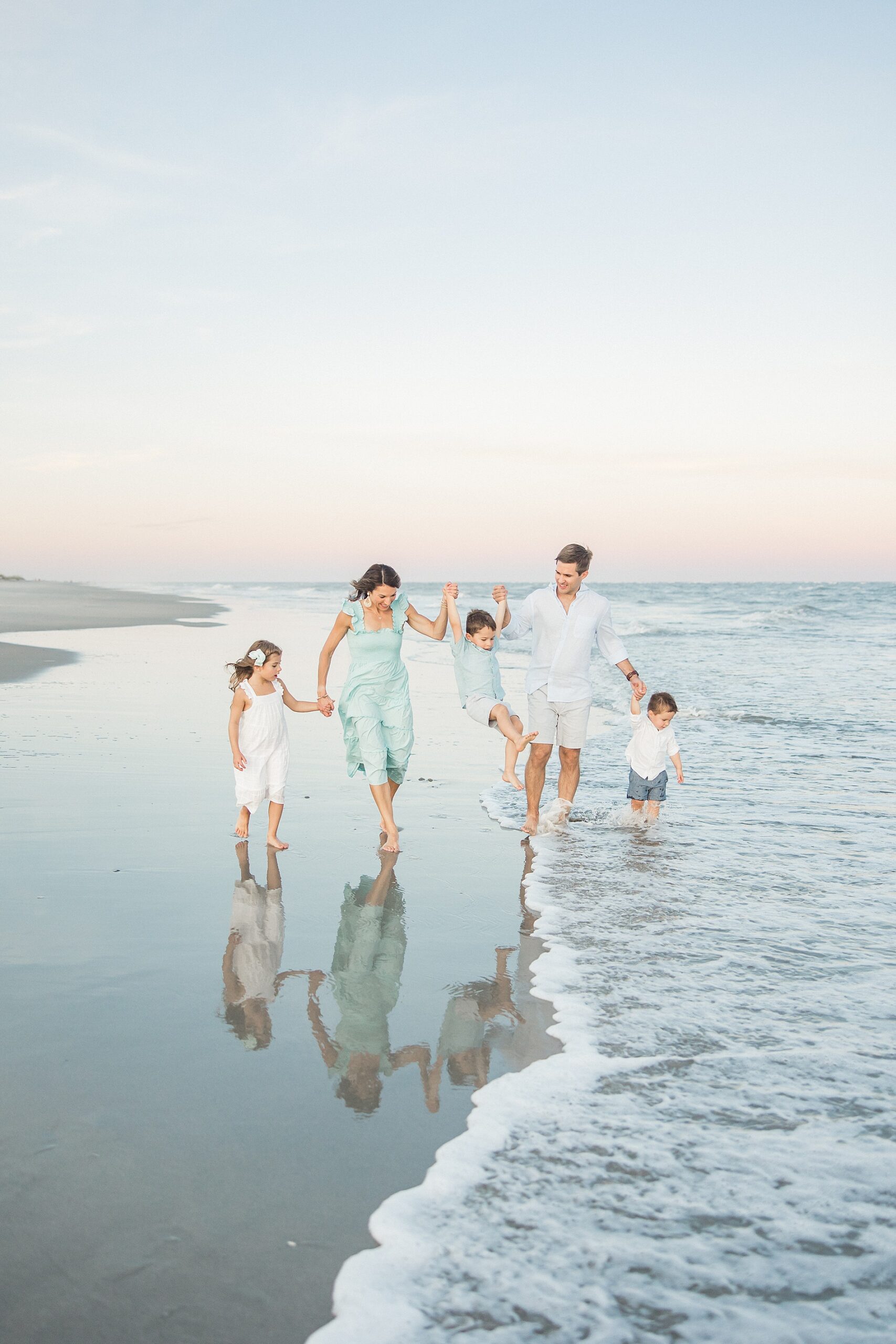 family walks along beach in South Carolina