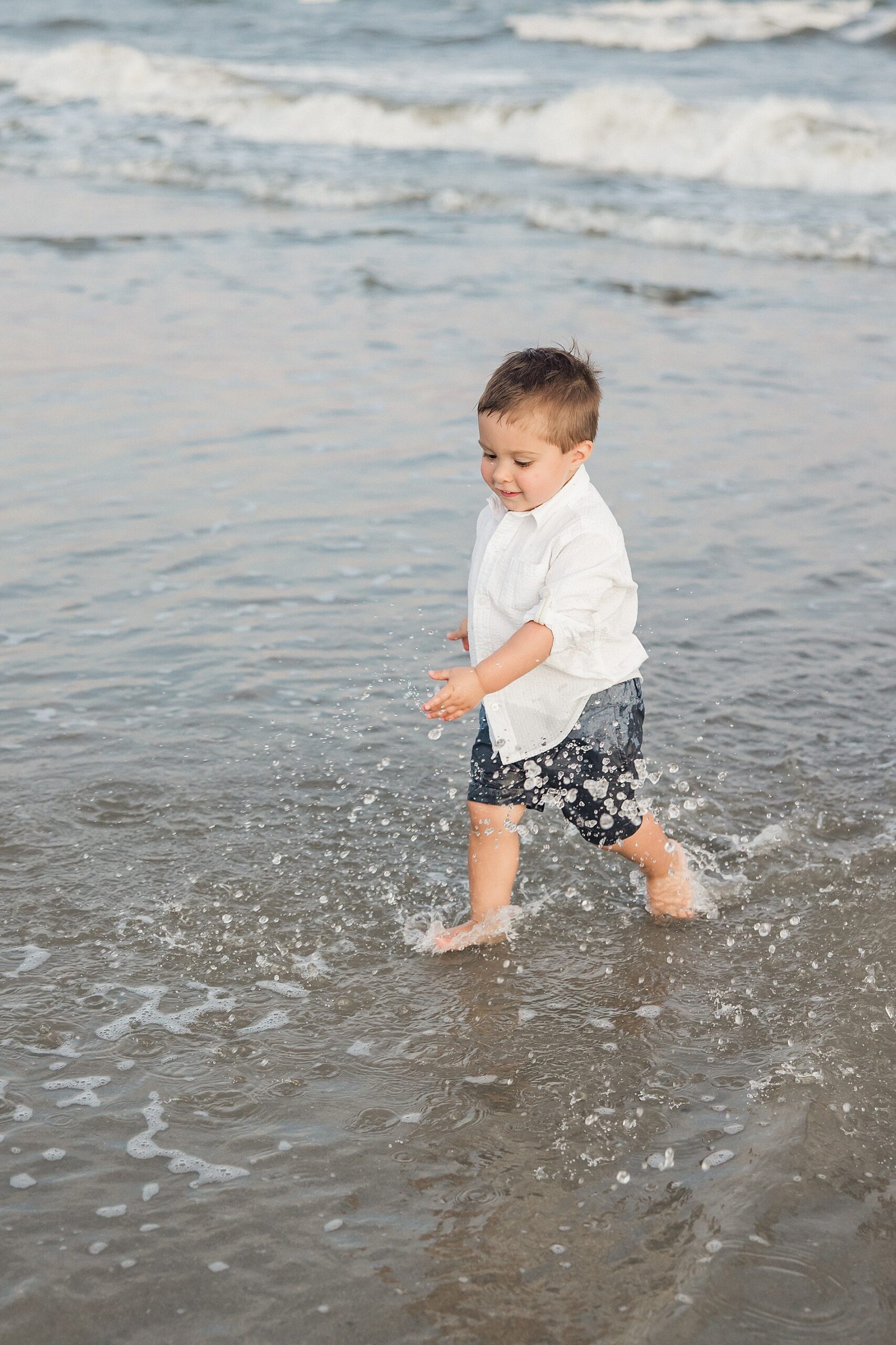 little boy splashes in water