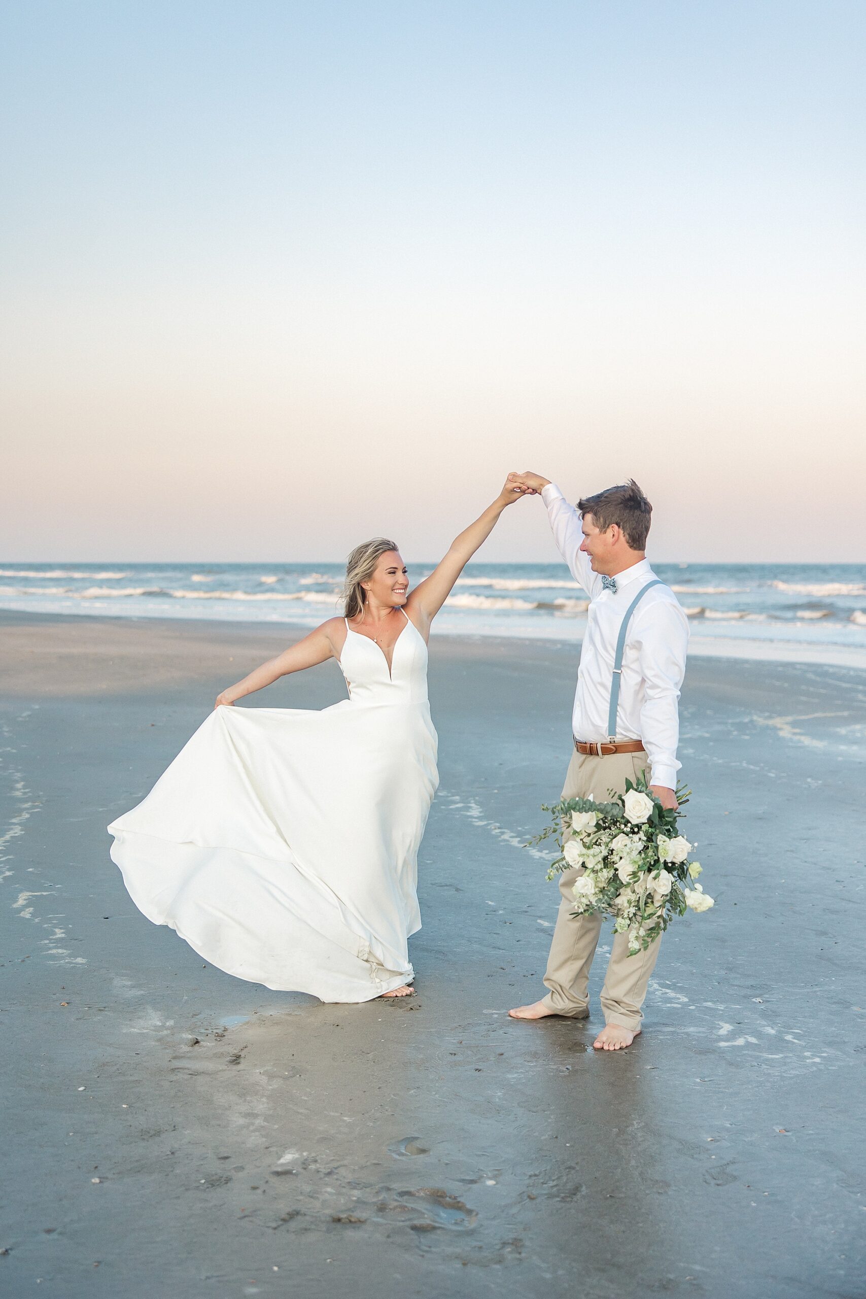 groom dances with his bride on the beach at Isle of Palms, SC