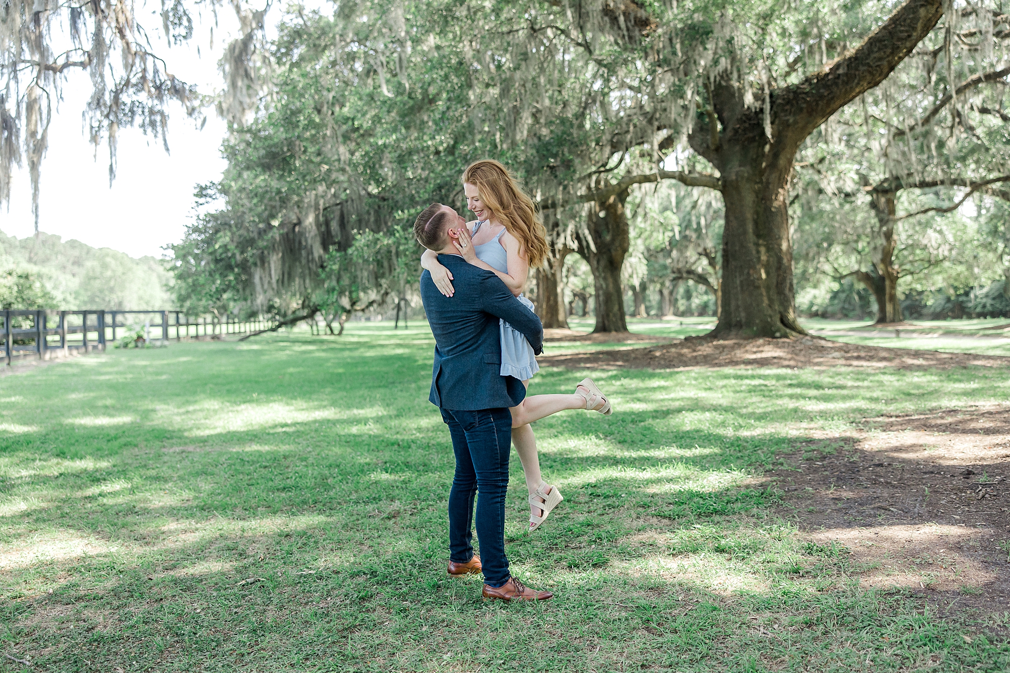 guy lifts his fiancé after Romantic Surprise Proposal at Boone Hall