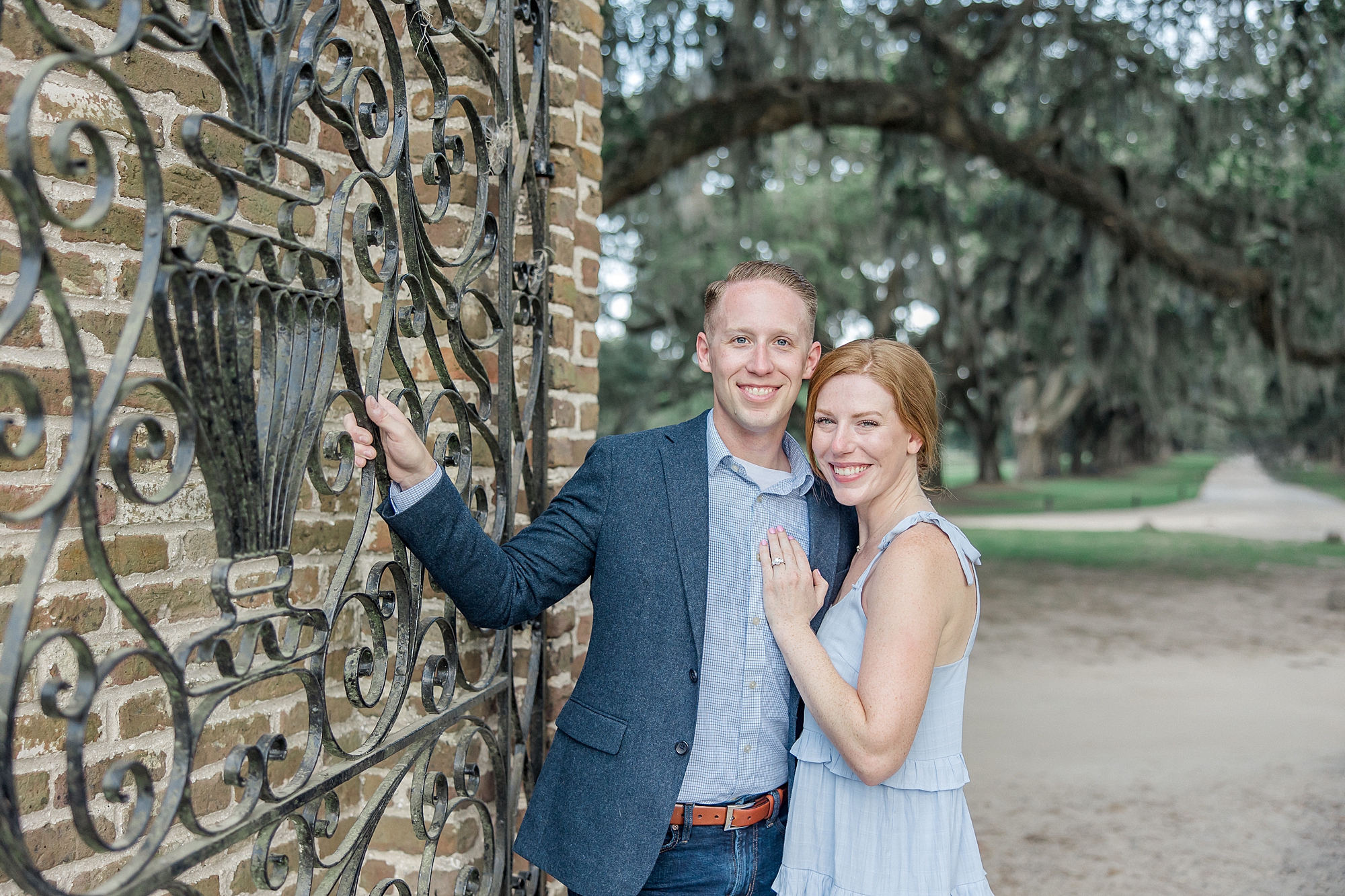 newly engaged couple at the gates of Boone Hall