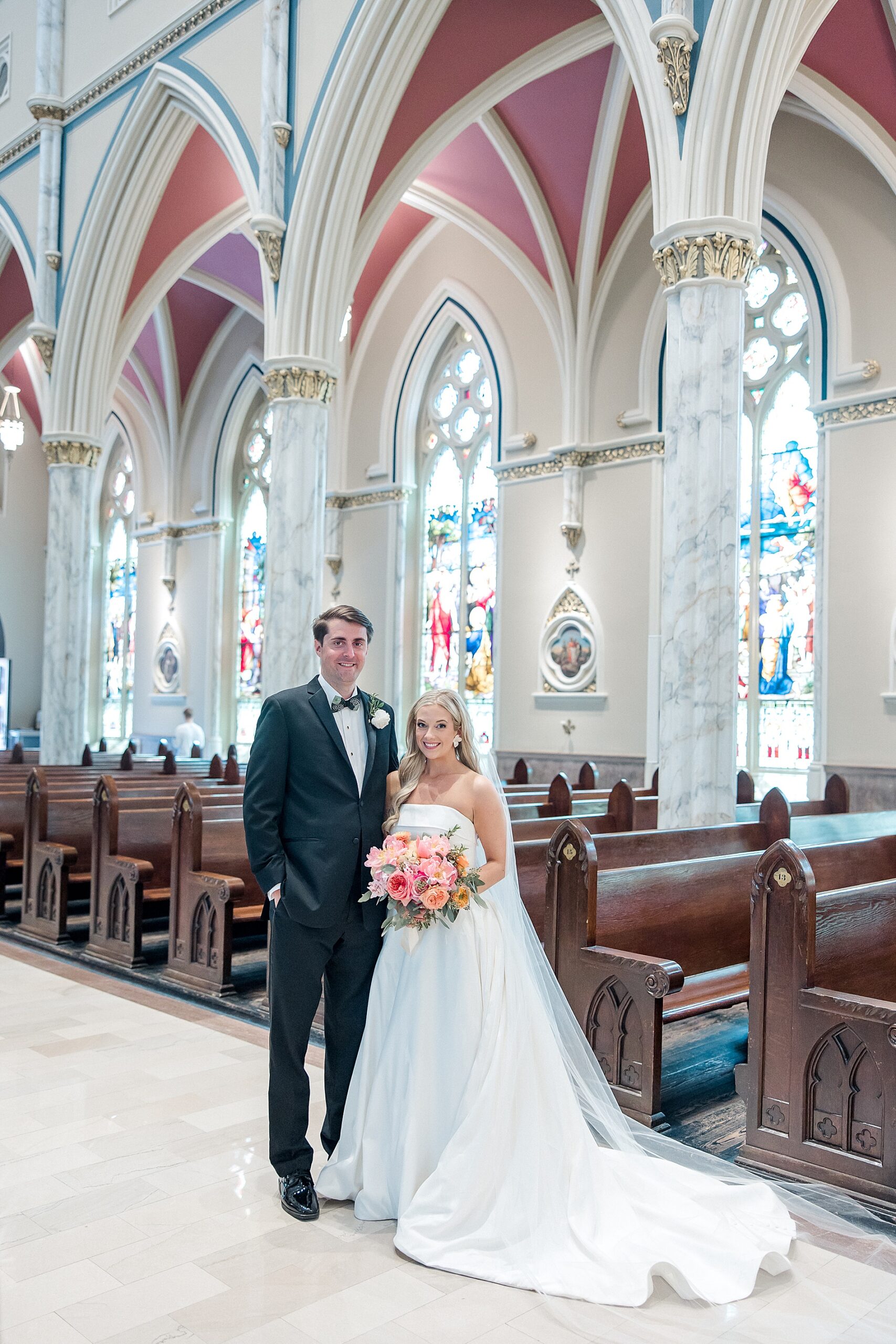 bride and groom inside church with stained glass windows