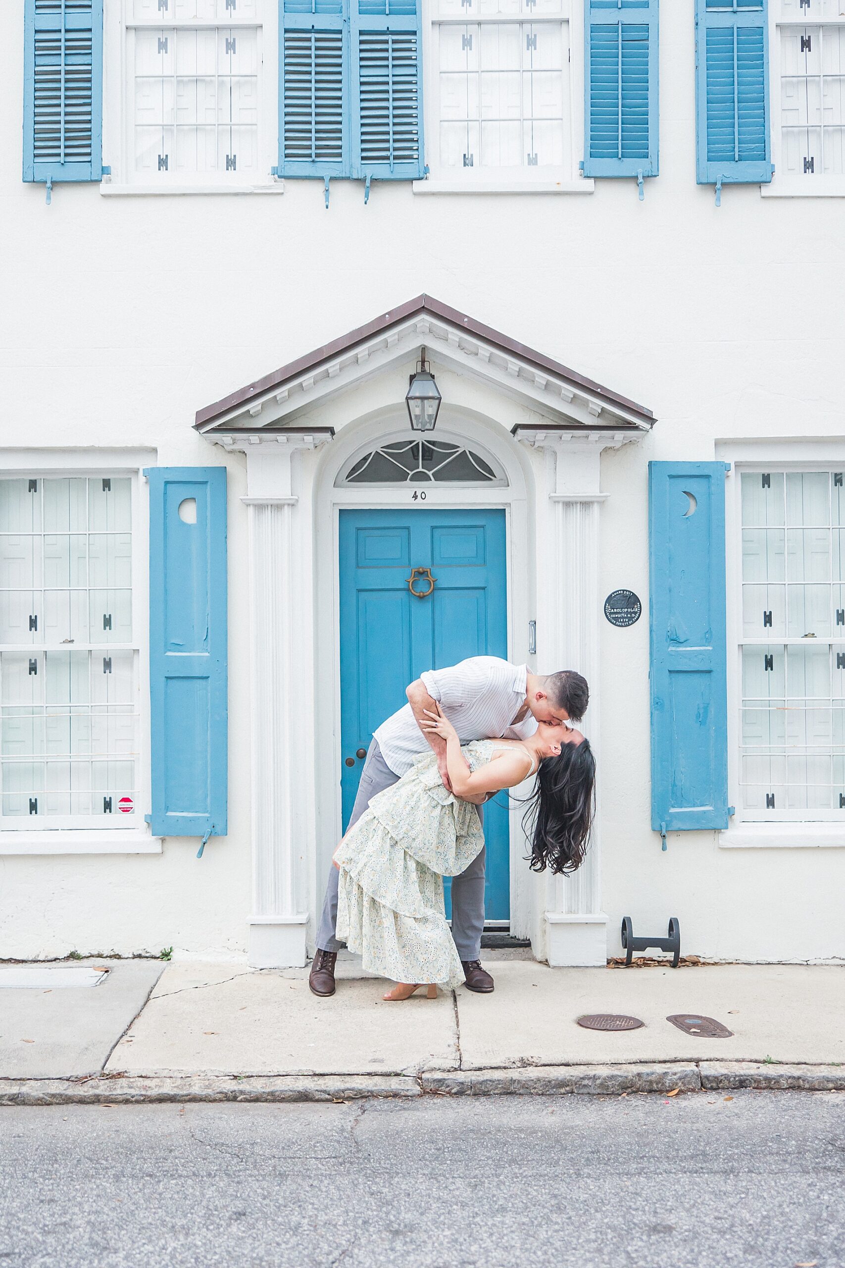 man dips his fiancé in front of building