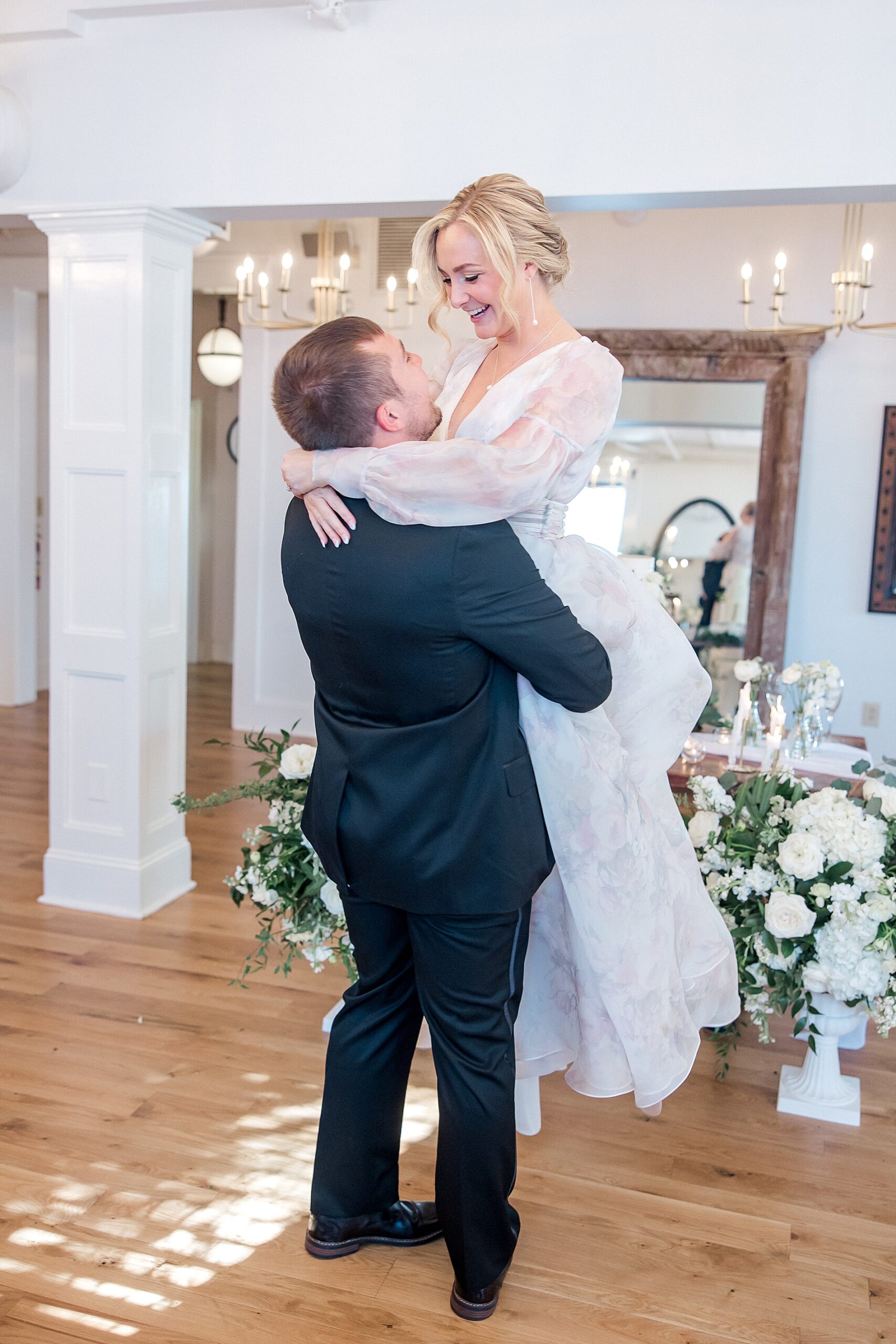 groom lifts bride on the dance floor