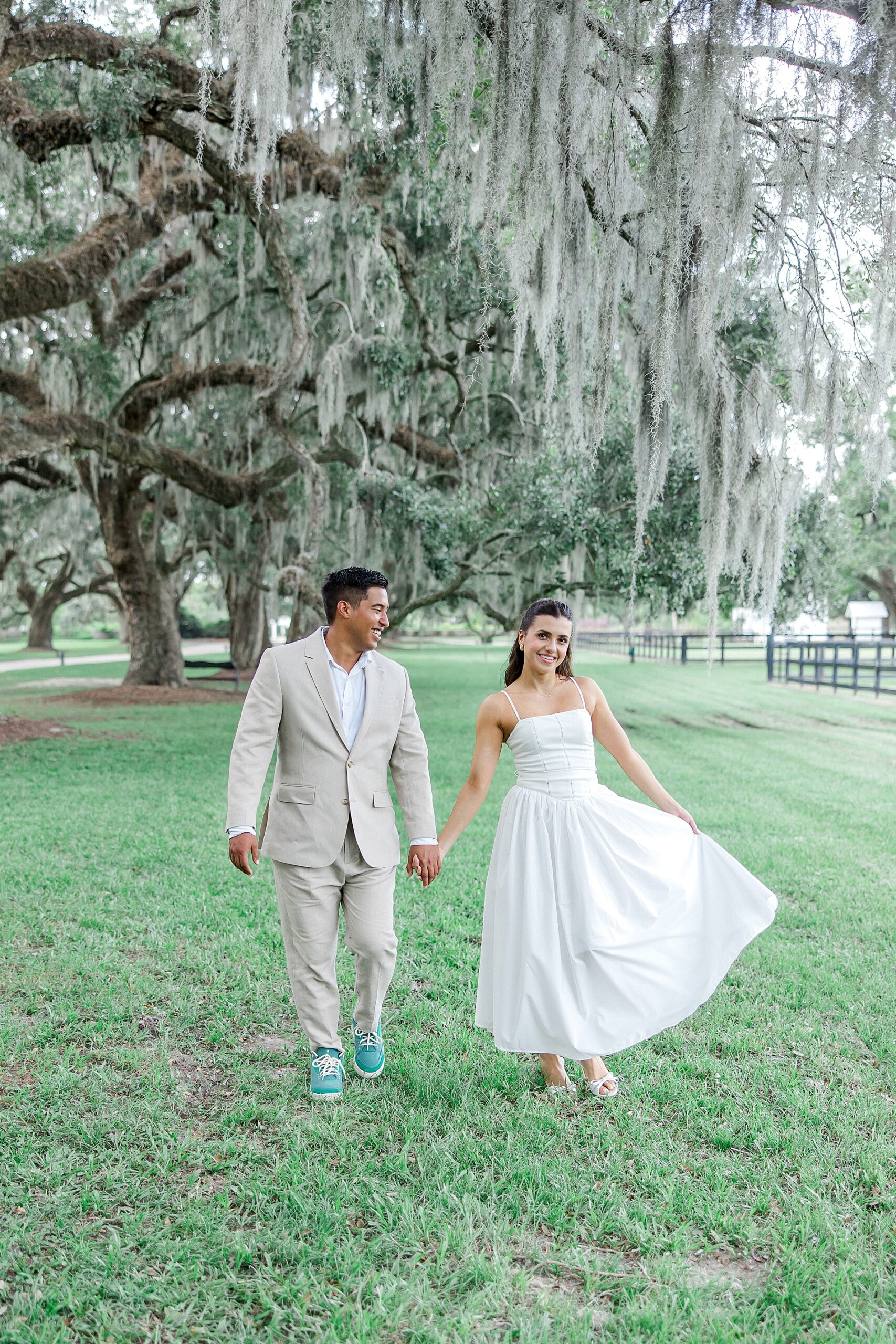 couple walk together holding hands at Boone Hall