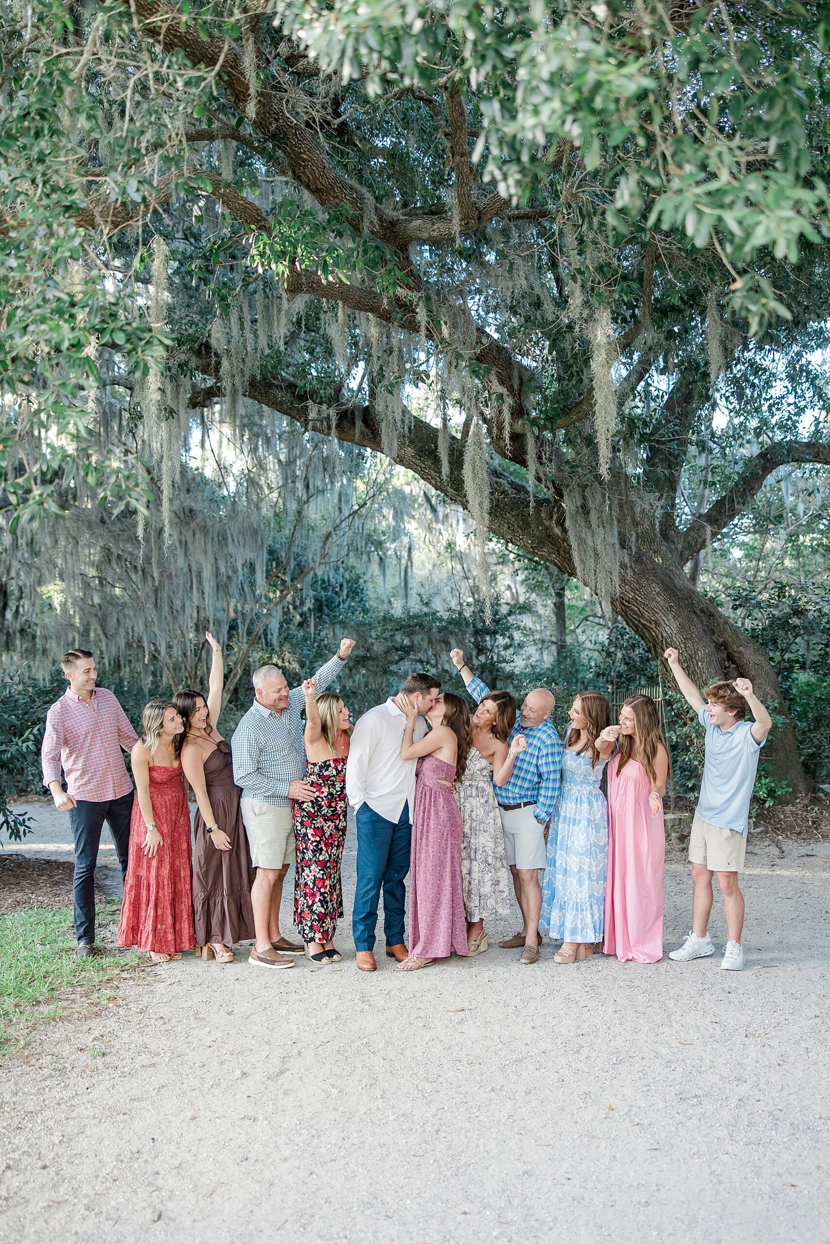 couple kiss with family around them