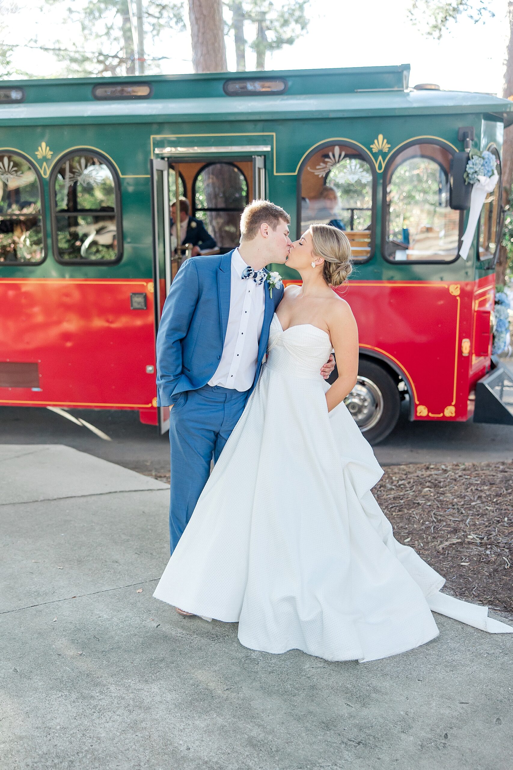 bride and groom kiss in front of Aiken Trolley
