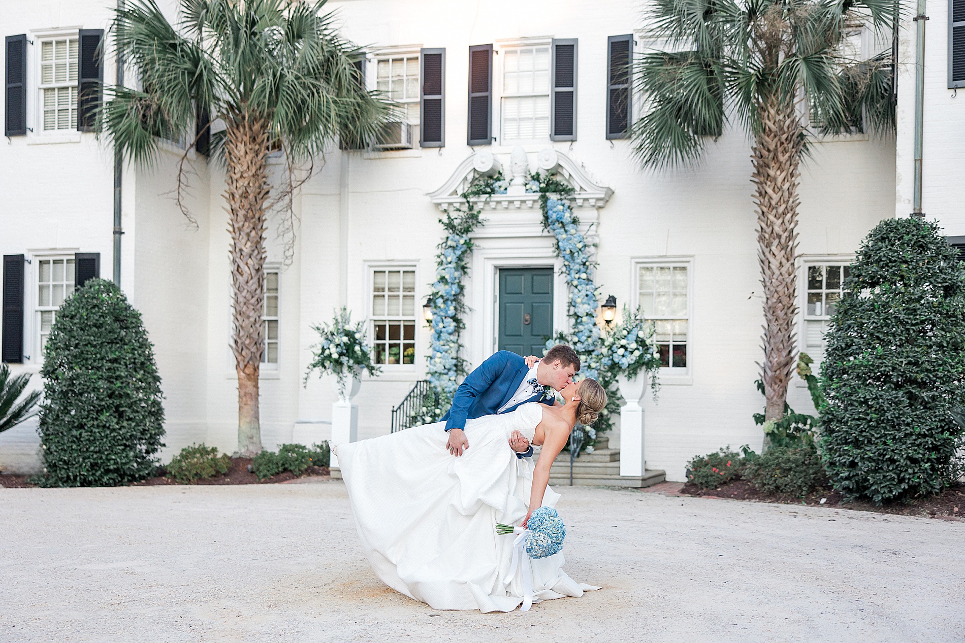 romantic newlywed portraits of couple kissing in front of wedding venue