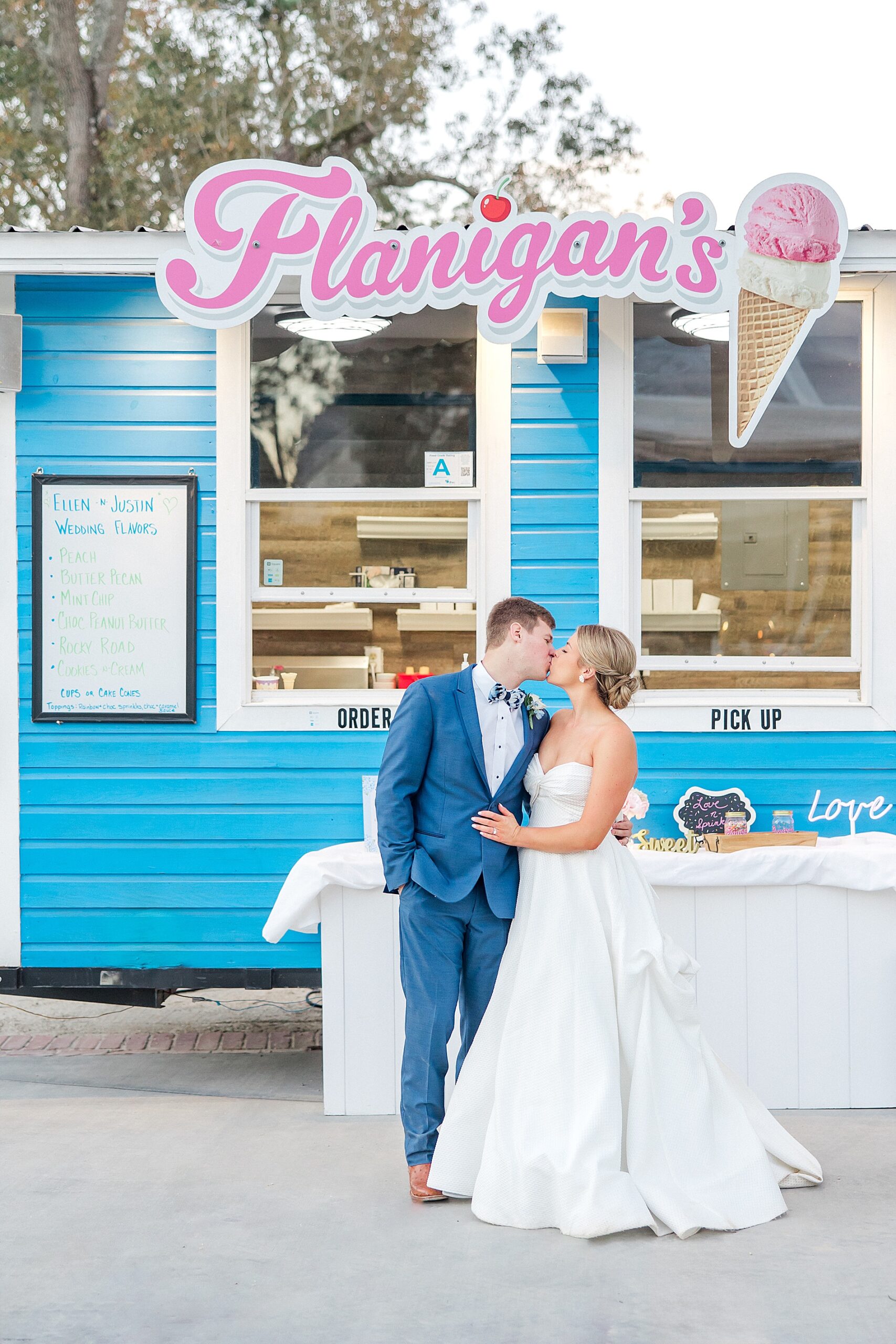 couple kiss in front of ice cream truck at wedding reception
