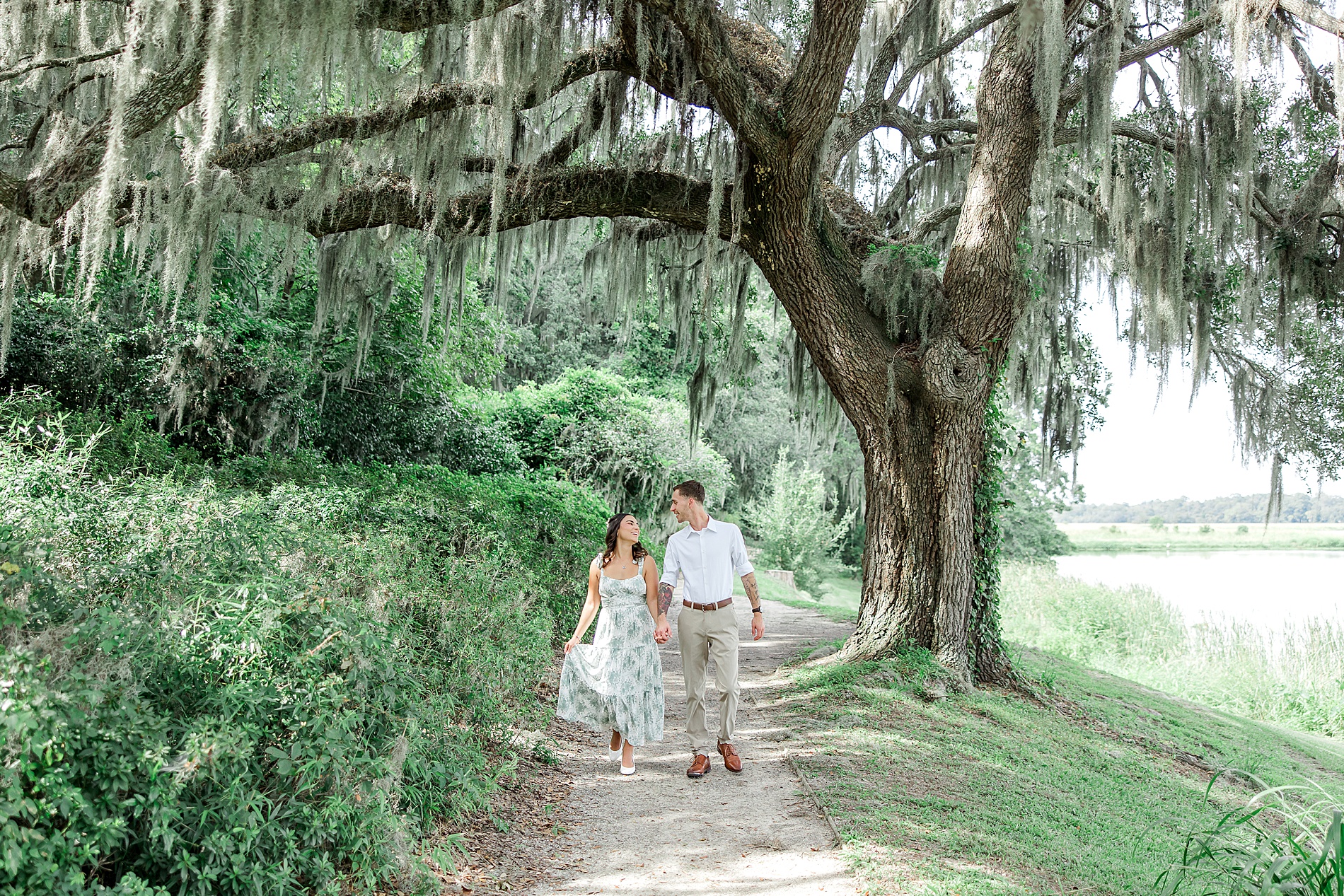 newly engaged couple walk through gardens at Middleton Place