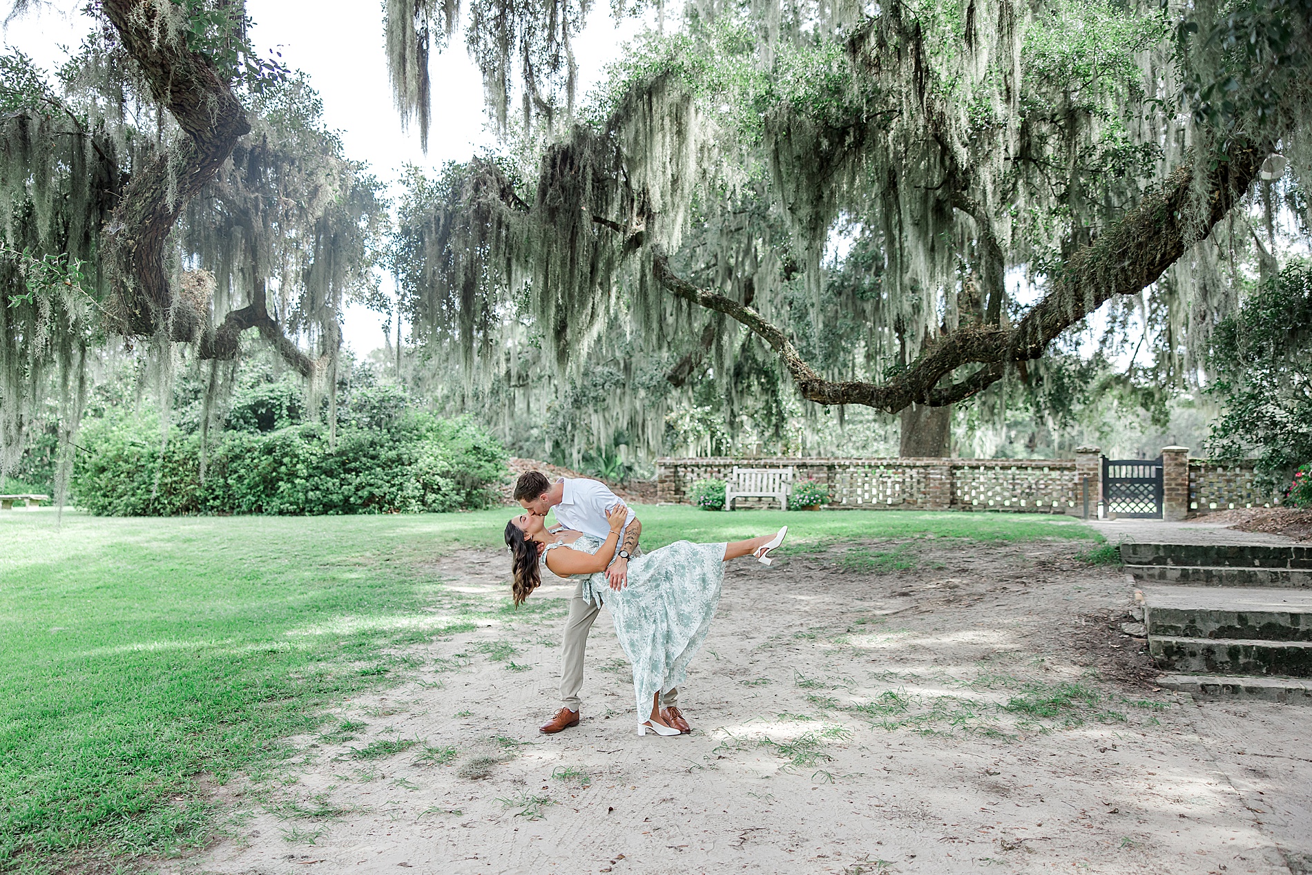 romantic kiss under Spanish moss covered oak tree