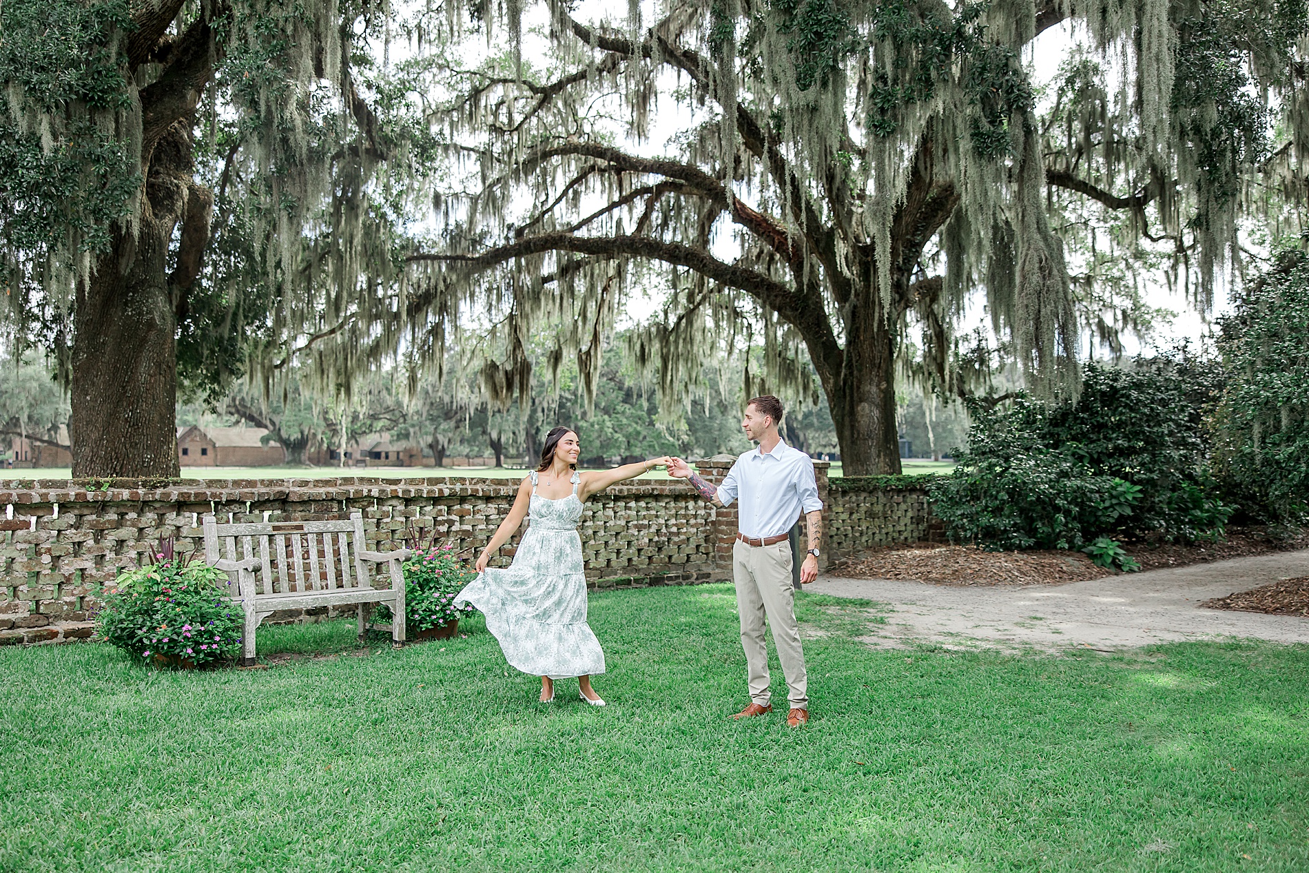 newly engaged couple dance in gardens